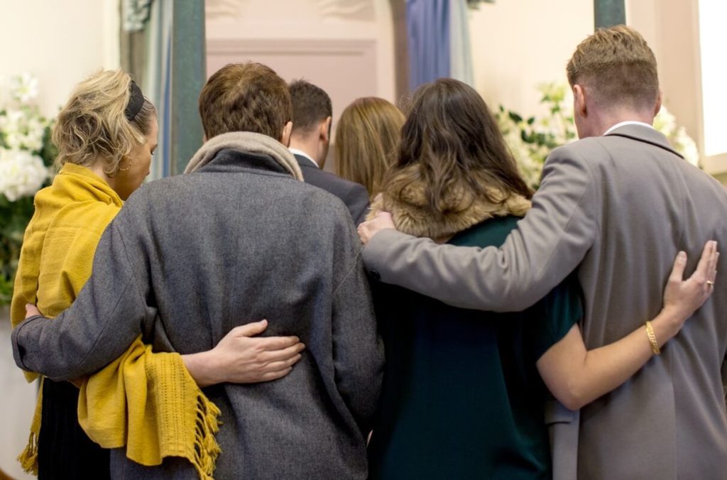 Blended family of deceased widower at the funeral. Children, stepchildren and adopted children may be entitled to dispute the will.